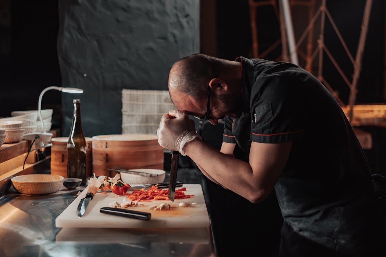 Chef focused on chopping vegetables in a restaurant kitchen ambiance.
